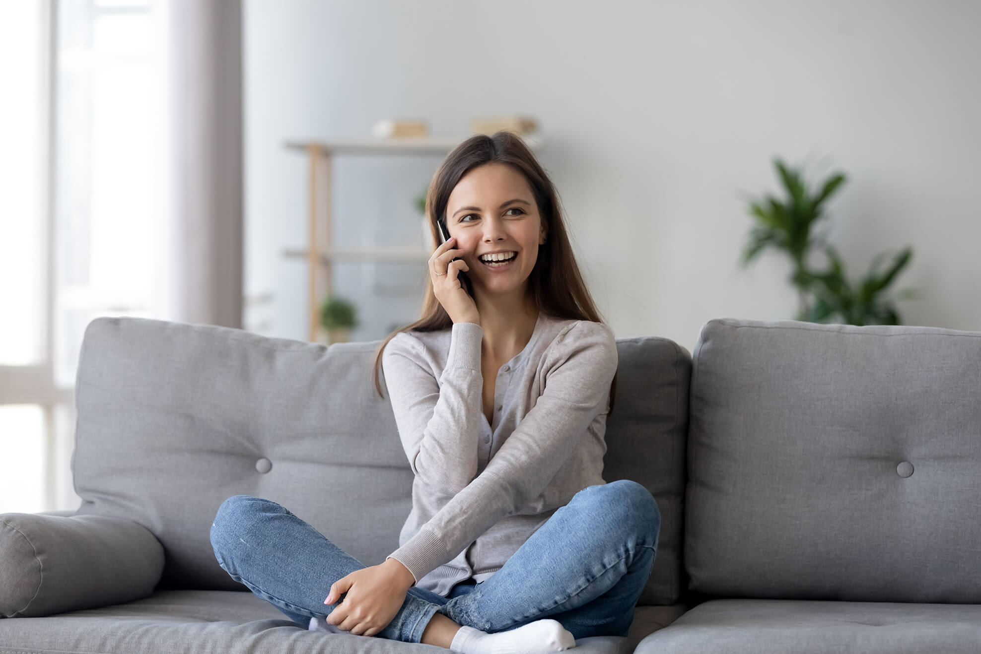 Frau telefoniert auf der Couch