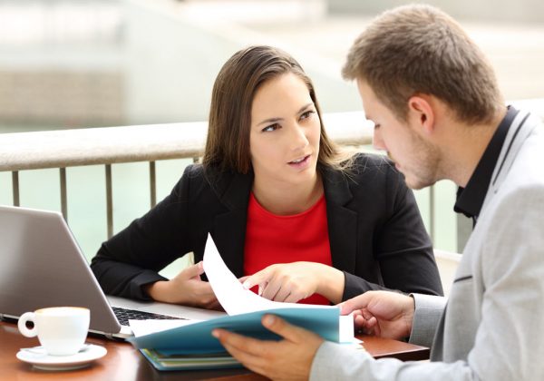 Intensive English one-to.one course. The teacher and the participant are sitting at a table outside.