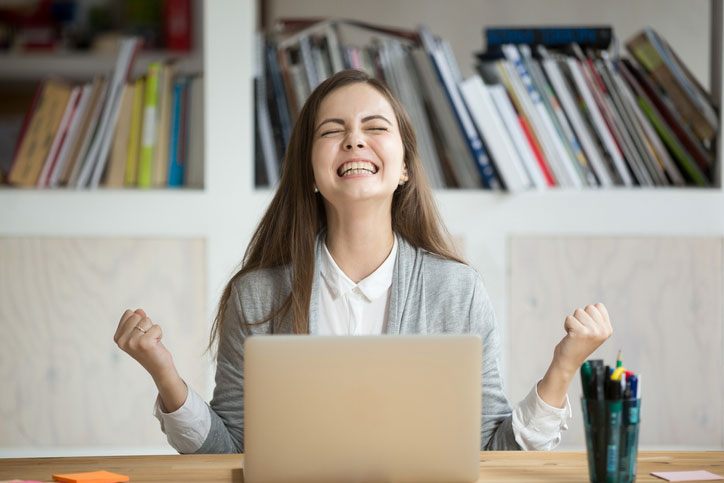 A young woman cheering as she has passed her English diploma test.