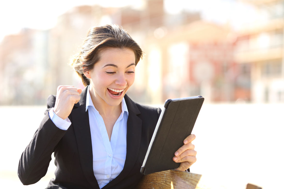 A business executive woman in an online video chat with her English teacher making a winner sign with her hand.