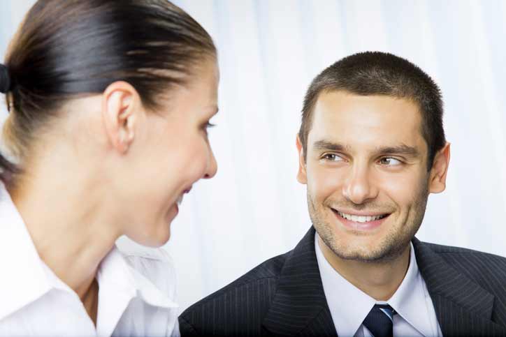 French course one-to-one. Teacher and participant in business dresses are smiling at each other.