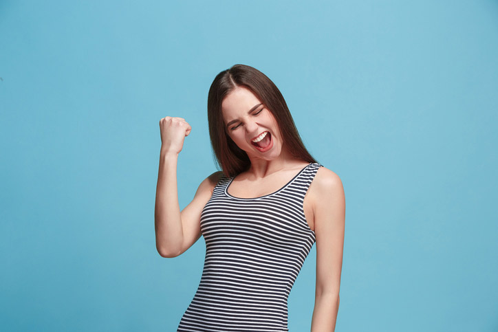 A young woman is cheering as she has passed her DELF French exam.