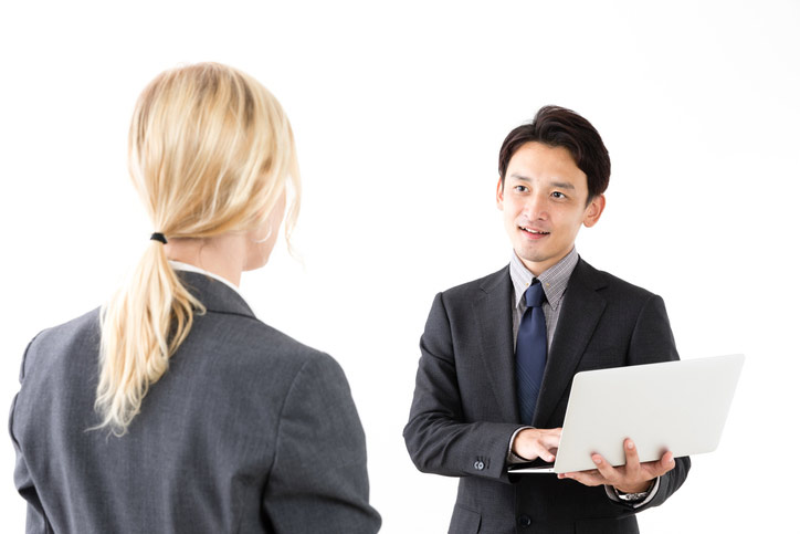 An intensive Japanese immersion course. The teacher is standing in front of the participant and is holding a laptop.