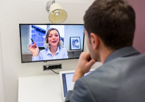 A young man is learning Russian online in a video conference. The teacher is explaining and is raising her hand - Photographer > getty images