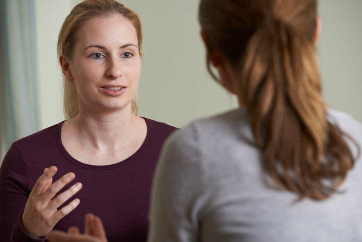 A Swedish one-to-one language course. The teacher and the student are sitting in front of each other and are talking to each other.