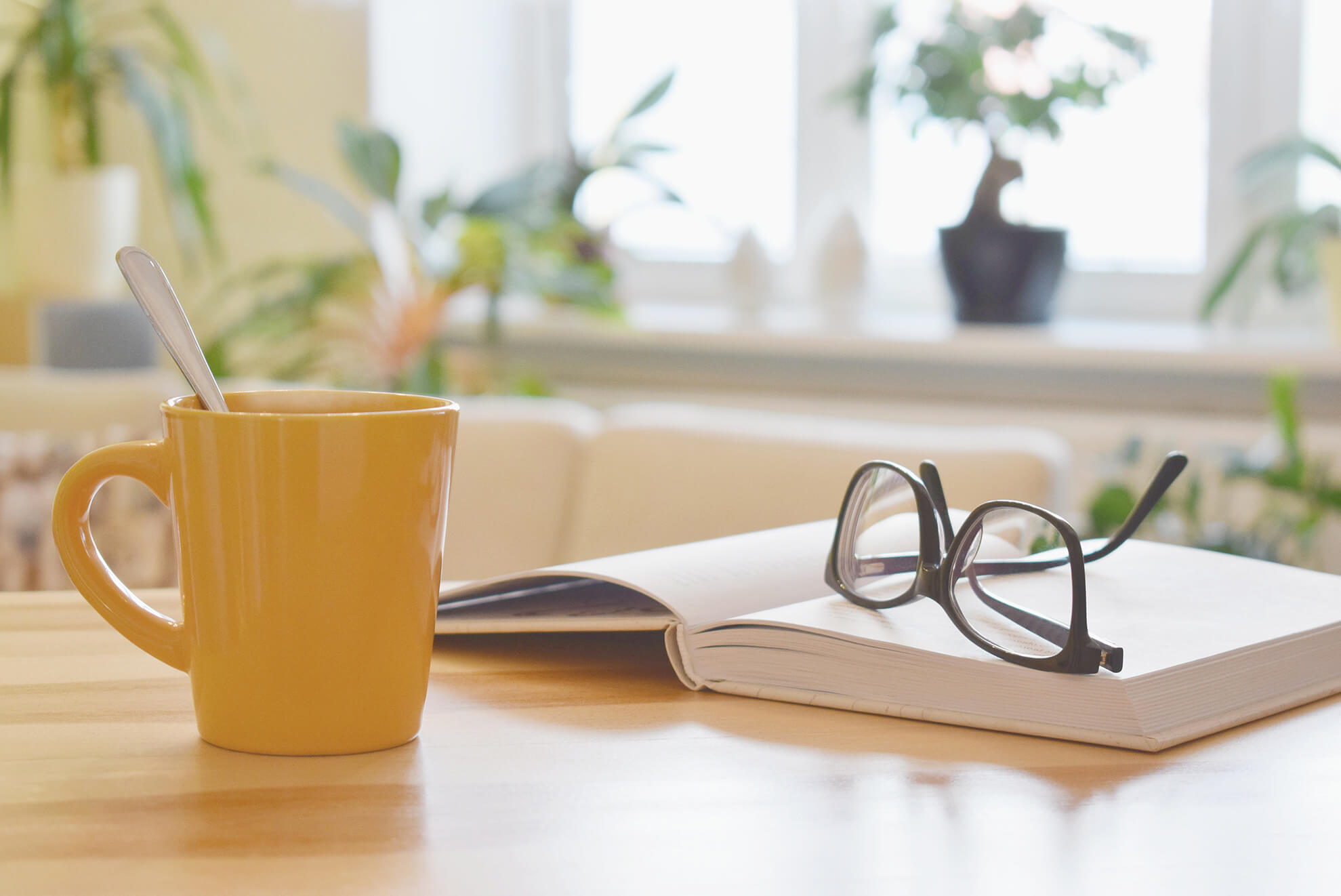 A book, glasses and a yellow cup - the perfect set-up for studying